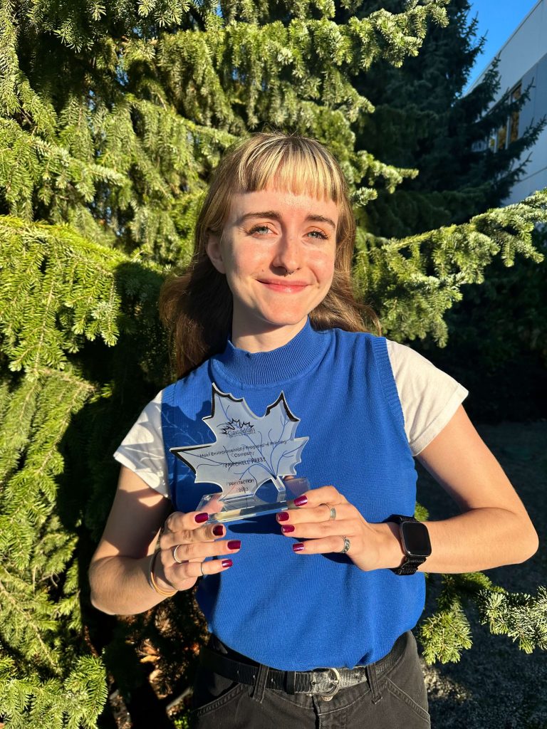 Mitchell's Environmental Award 2023 held by Sustainability Specialist Holly Denson-Camp in front of a tree